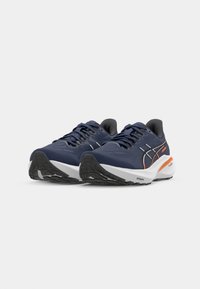 Blue running shoes with black accents, textured fabric, white midsole, and orange details; featuring a lace-up design and patterned outsole.