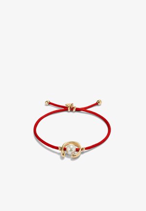 Bracelet en corde rouge réglable avec un fermoir central doré incurvé tenant une perle blanche unique.