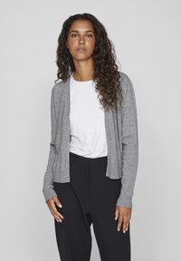Grijze cardigan van zacht materiaal, met een open voorkant, ribbelmanchetten en zoom, gedragen over een wit shirt en zwarte broek. Glad textuur met een casual pasvorm.