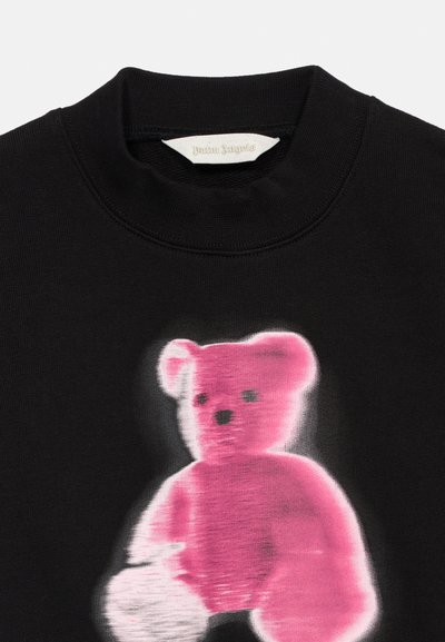 Μαύρο φούτερ με θολό ροζ γραφικό αρκουδάκι στο κέντρο κάτω από ριμπ λαιμόκοψη και λευκή ετικέτα σχεδιαστή στο εσωτερικό του γιακά.