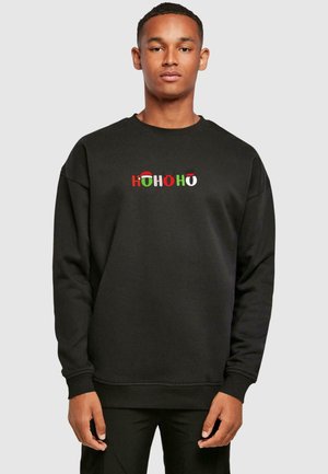 Black sweatshirt featuring "HOHOHO" text in red, green, and white with festive accents like Santa hats and reindeer. Casual fit with ribbed cuffs.