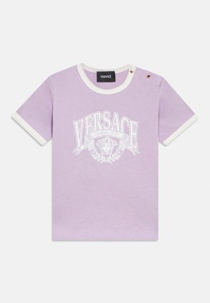 T-shirt en coton lilas à manches courtes avec bordure blanche, deux boutons dorés aux épaules et logo Versace blanc avec graphique de tête de Méduse sur le devant.