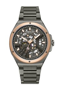 Automatisk klocka med en svart skelettskiva och roséguldfärger, en klocka i rostfritt stål och armband samt vinklade timmarkörer.