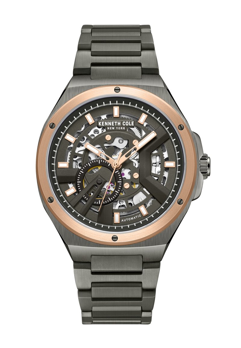Automatisk klocka med en svart skelettskiva och roséguldfärger, en klocka i rostfritt stål och armband samt vinklade timmarkörer.