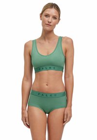 Groene naadloze bralette en bijpassende hipster onderbroek met een brede band met het "FALKE" logo. Zachte textuur, relaxte pasvorm en ronde hals.