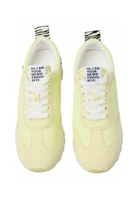 Lime yellow sneakers with a textured upper, white laces, and a zebra-print heel tab. Features a tag with printed text on the tongue.