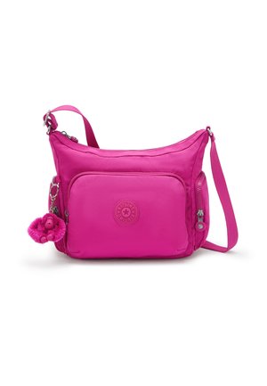 Pink nylon crossbody bag with a zippered front pocket, adjustable strap, and furry monkey keychain. Features a round logo patch.