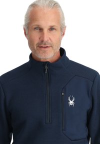 Pullover blu navy con zip a un quarto, tessuto testurizzato e tasca a toppa con un logo bianco di un ragno sul petto.