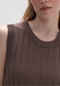Top sin mangas de color marrón con cuello redondo, con rayas verticales y un tejido texturizado, que muestra un material suave y elástico.