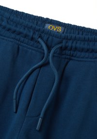 Marineblauwe sweatpants van katoen, met een elastische tailleband met een trekkoord en subtiele stiksels langs de randen. OVS-label zichtbaar.