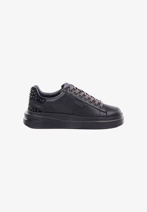 Sneaker nero low-top con lacci grigi, dettaglio tacco borchiato e suola spessa, con marchio "Guess" sul lato e sulla suola.