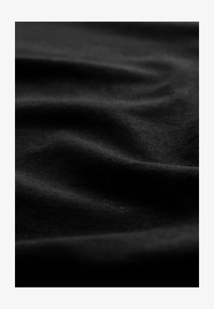Zwarte stof met een gladde textuur, die zachte plooien en een subtiele glans vertoont, waarbij kleurvariaties en oppervlaktedetails worden benadrukt.