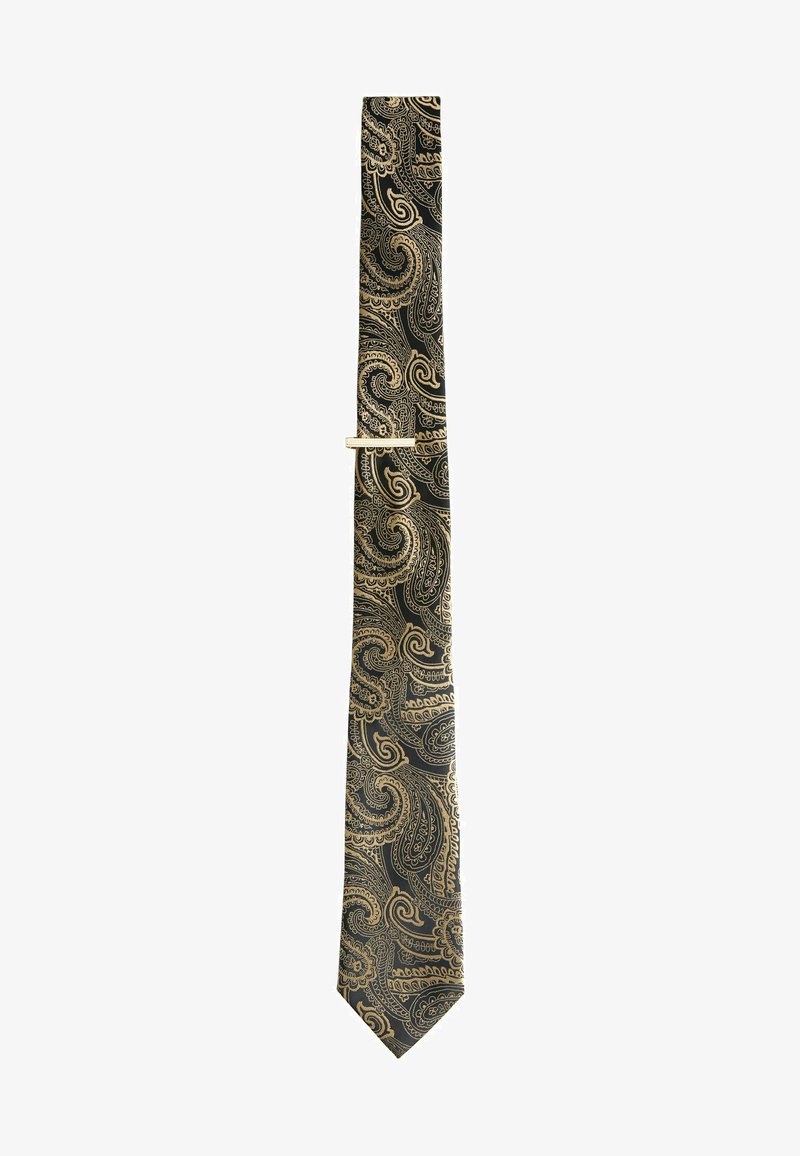 Svart fluga med intrikat guld paisley mönster, tillverkad av siden, med en spetsig spets och slimmad design, säkrad med en guld flugklipp.