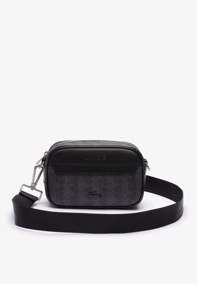 Sac à bandoulière rectangulaire noir en matériau synthétique texturé avec un panneau supérieur lisse, arborant un logo de marque et une sangle ajustable.