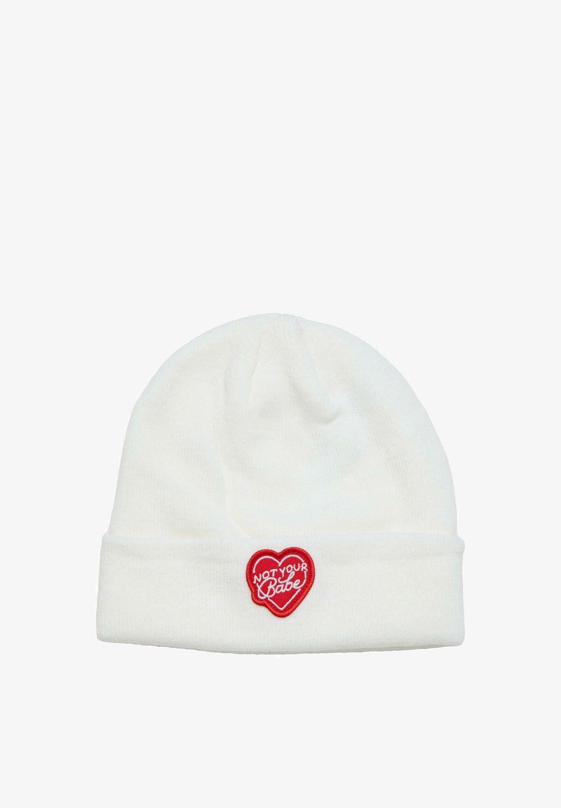 Witte gebreide beanie met een omslag, voorzien van een rood hartvormig logo met de tekst "NOT YOUR BABE" in witte letters. Zachte textuur.