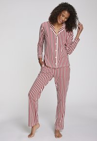 Rood-witte gestreepte pyjama set met een knoopsluiting shirt en bijpassende broek. Comfortabele stof, klassieke kraag en lange mouwen.