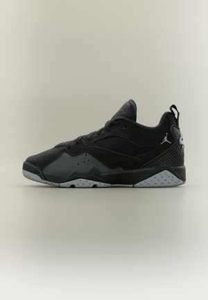 Baskets basses noires et grises avec détails en mesh, lacets et logo Jumpman sur le talon, sur un fond clair uni.
