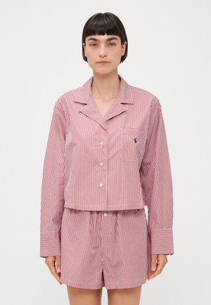 Conjunto de pijama a rayas rojas y blancas que incluye una camisa de botones con cuello y mangas largas, y pantalones cortos a juego con cintura elástica y bolsillo.