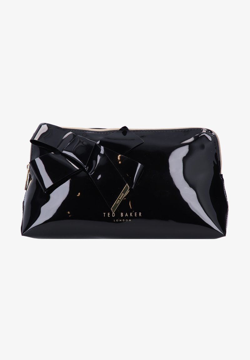 Juoda lakuota odinė kosmetinė su kaspino detalėmis priekyje ir aukso spalvos logotipu. Lygus paviršius, užtrauktukas viršuje, elegantiška stačiakampio forma.