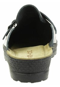 Svart sandal med en vävt texturerad sula, inre av mocka och ett band på sidan. Fotbädden är vadderad och formad för komfort.