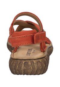 Sandalia de cuero rojo con múltiples correas, que cuenta con una suela marrón texturizada y una plantilla acolchada. Correa ajustable para un ajuste seguro.
