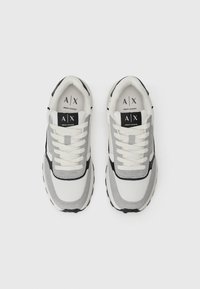 Para białych i szarych sneakersów Armani Exchange z sznurówkami, widzianych z góry na jednolitym białym tle.