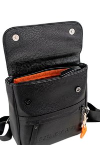 Bolso de cuero negro con superficie texturizada, interior naranja, compartimento con cremallera, cierre magnético y acento de logo en la parte frontal.