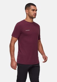 Bordeauxkleurig T-shirt met korte mouwen, gemaakt van zacht materiaal, met een subtiele logo op de borst, ronde halslijn en een relaxte pasvorm.