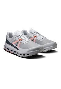 Scarpe da corsa leggere in grigio, con tomaia in mesh bianco con dettagli rosa e blu navy, colletto imbottito e suola ammortizzata distintiva.