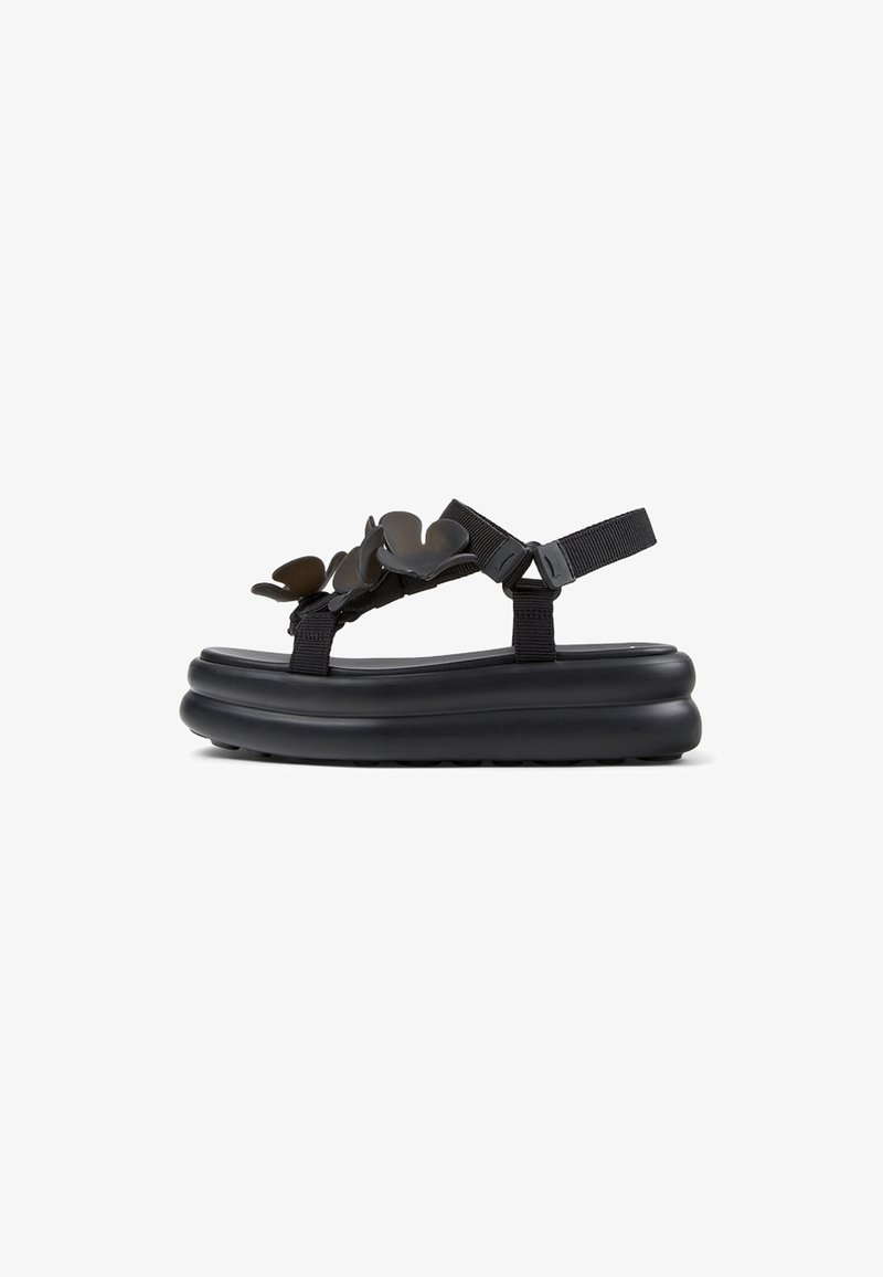 Schwarze Plateausandalette mit dicker Sohle, verstellbaren Riemen und dekorativen Schmetterlingsakzenten am oberen Riemen.