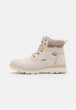 Bottine beige à lacets sur le devant, col tricoté, semelle épaisse et logo de la marque "Xti" sur le côté.