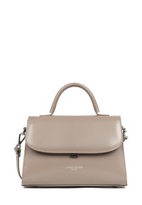 Sac à main en simili cuir beige avec une poignée supérieure et une bandoulière amovible. Il dispose d'une fermeture à rabat et d'un logo de marque gravé à l'avant.