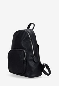 Mochila de cuero negro con forma redondeada, que cuenta con un bolsillo con cremallera en el frente, detalles texturizados y detalles en hardware plateado. Correa ajustable.