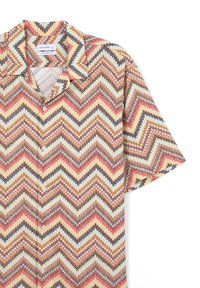 Camicia a maniche corte con bottoni in un tessuto leggero, caratterizzata da un motivo a zigzag in toni di arancione, giallo, nero e crema. Vestibilità rilassata.