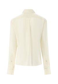 Long-sleeve, light beige blouse with a classic collar, buttoned cuffs, smooth texture, and a vertical seam running down the back.