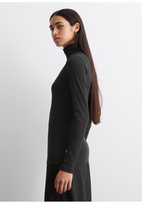 Schwarz, langärmliges Rollkragenshirt mit figurnahem Design und geripptem Textur. Der Stoff wirkt weich, leicht und dehnbar. Schlichte und elegante Silhouette.