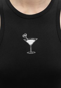 Μαύρο φανελάκι με λευκό περίγραμμα ποτηριού μαρτίνι και αναδευτήρα σε σχήμα καρδιάς με την ετικέτα "Hug" στο κέντρο του στήθους.