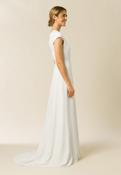 Robe blanche longue jusqu'au sol avec des manches courtes, un corsage ajusté et un dos ouvert. Tissu lisse avec un léger éclat.
