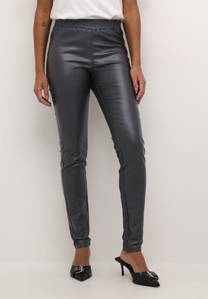 Grijze, hoog-taille slim-fit broek met een glanzende afwerking. Soepele textuur met zijdetails en een lengte tot de enkel. Gepaard met zwarte puntige hakken.