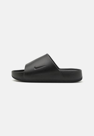 Sort Nike slidssandal med en bred rem og tekstureret sål, vist fra siden på en ensartet lys baggrund.