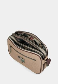 Beige Umhängetasche mit geprägtem Muster, mehreren Reißverschlussfächern, einer Vordertasche mit Reißverschluss und einem Innenfutter aus Stoff mit buntem Druck.