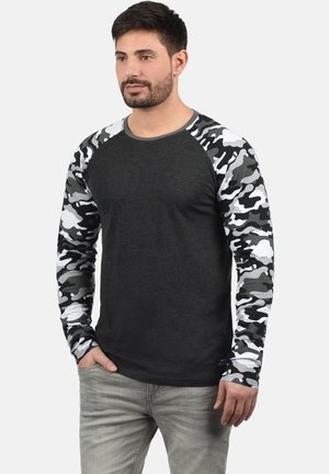 Long-sleeve T-shirt with a dark gray body and black-and-white camouflage patterned sleeves. Features a crew neckline and relaxed fit.