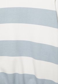 Vzorec vodoravnih črt v izmeničnih svetlo modri in beli barvi na tkanini, z mehko, gladko teksturo.