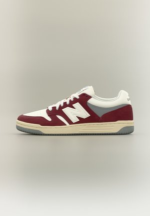Baskets basses en bordeaux, blanc et gris avec des lacets blancs et une semelle beige, montrant le profil latéral gauche.