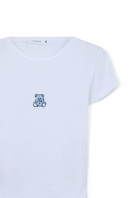 T-shirt bianca in cotone con colletto rotondo e maniche corte, caratterizzata da un piccolo orsetto blu ricamato sul davanti. Taglia S.