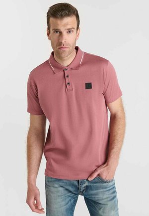Polo à manches courtes en rose pâle, en mélange de coton, avec un col, une patte de boutonnage à trois boutons et des détails en blanc contrastant.
