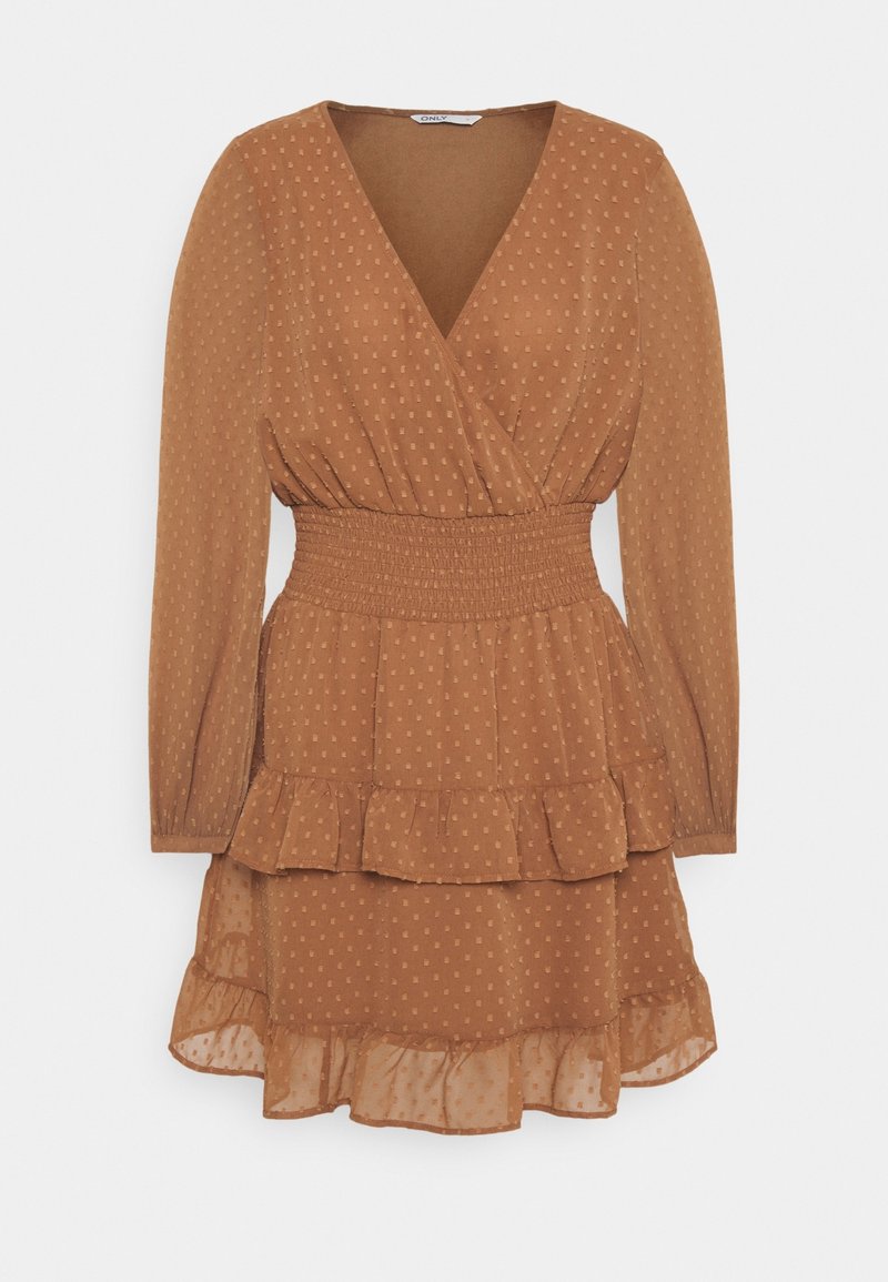 Robe portefeuille marron à pois avec une taille smockée, des manches longues et un ourlet à volants. Réalisée en tissu léger et texturé.