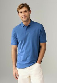 Kortærmet polo t-shirt i mellemblå, med krave og tre knapper, lavet af glat stof med et subtilt logo på brystet.