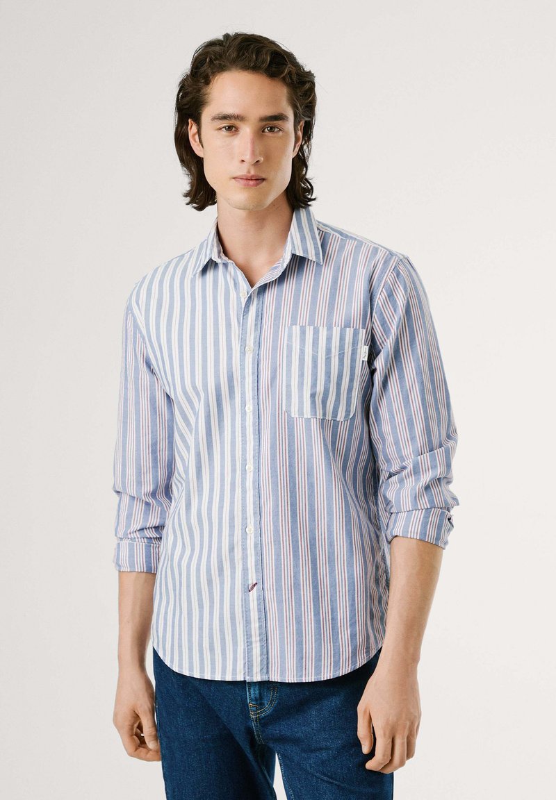 Camisa de botones a rayas azul claro y blanca con un bolsillo en el pecho. Tela de algodón, mangas largas, ligera y con dobladillo redondeado.
