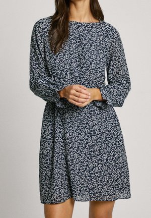 Marineblaues Kleid mit einem weißen Blumenmuster, langen Ärmeln, rundem Ausschnitt und einer taillierten Passform mit ausgestelltem Rock. Leichte Stoffstruktur.